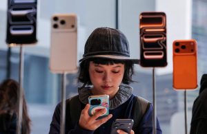 A woman uses her smartphone inside the Apple store in Beijing's Sanlitun area as the new iPhone 17 series smartphones go on sale in Beijing, China September 19, 2025. REUTERS/Maxim Shemetov