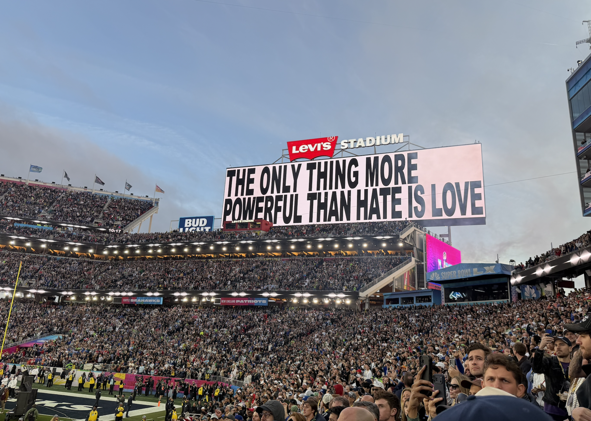 A jumbotron displays the phrase "The only thing more powerful than hate is love" at the end of Bad Bunny's performance